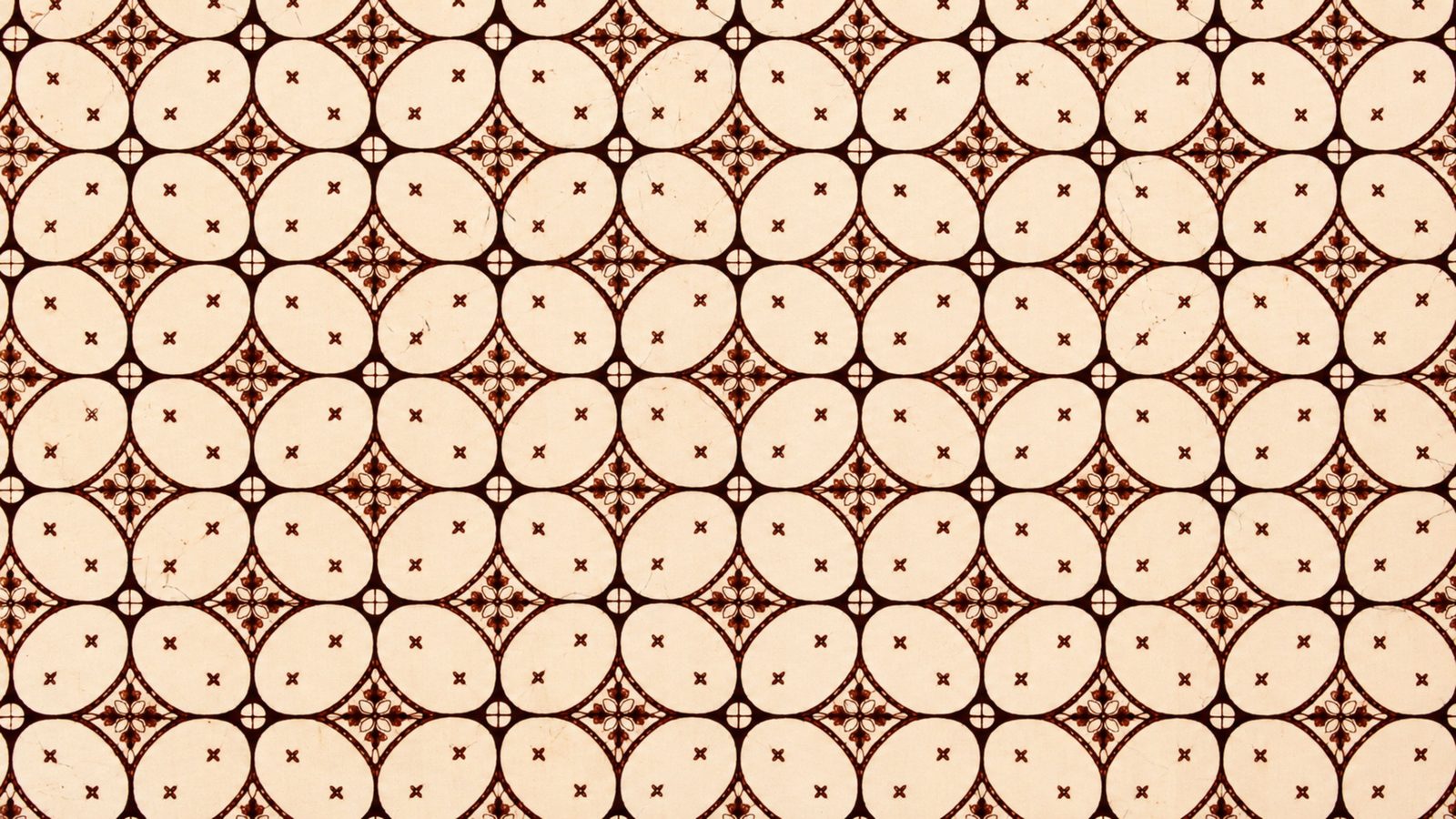 Motif batik kawung bernuansa cokelat sogan dengan pola bulatan yang tersusun rapi
